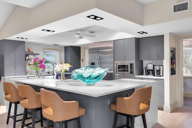 3300 Riviera Dr, Key West, FL 33040 - kitchen with built in appliances, light wood finished floors, gray cabinetry, modern cabinets, and a raised ceiling