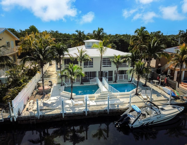 rear view of house featuring a balcony, a patio, fence, and a community pool