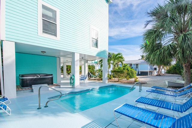 view of pool featuring a hot tub and a patio