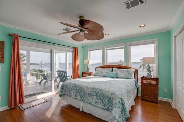 bedroom with multiple windows, wood-type flooring, ornamental molding, and access to exterior