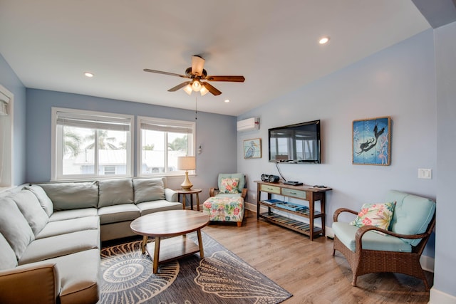 living room with vaulted ceiling, an AC wall unit, ceiling fan, and light hardwood / wood-style floors