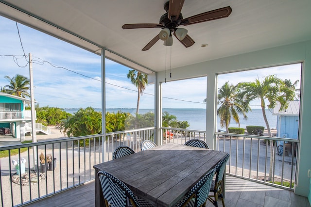 sunroom / solarium with a water view and ceiling fan