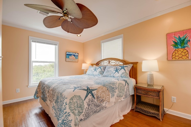 bedroom with hardwood / wood-style flooring, crown molding, and ceiling fan