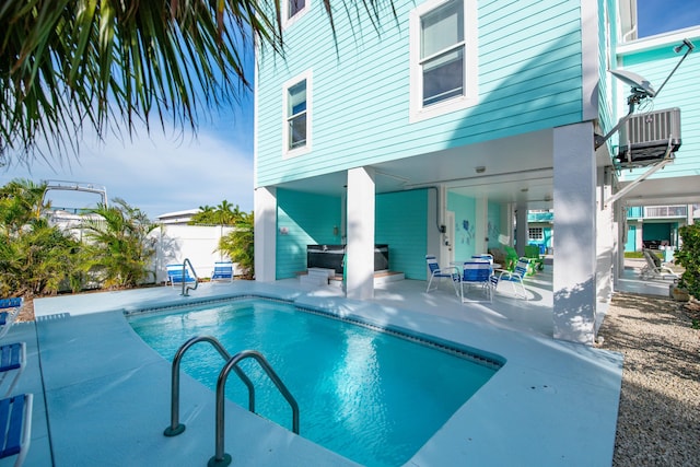 view of swimming pool featuring central AC unit and a patio area