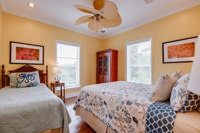 bedroom featuring hardwood / wood-style flooring, crown molding, and ceiling fan