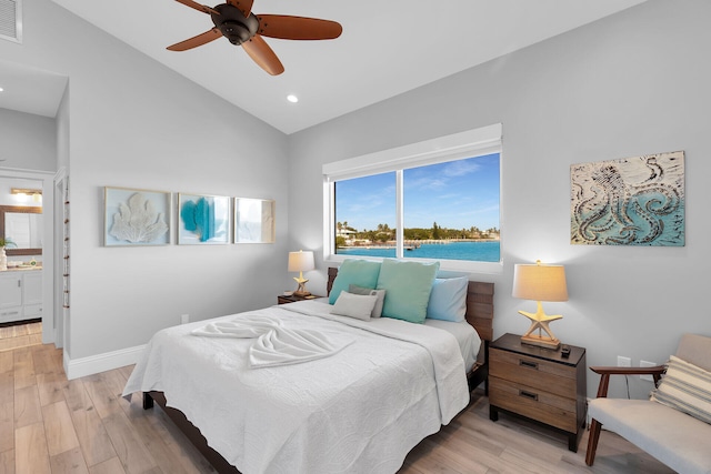 bedroom featuring hardwood / wood-style flooring, ensuite bath, ceiling fan, and vaulted ceiling