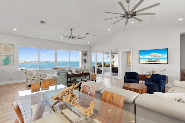 living room featuring a water view, high vaulted ceiling, ceiling fan, and light hardwood / wood-style floors