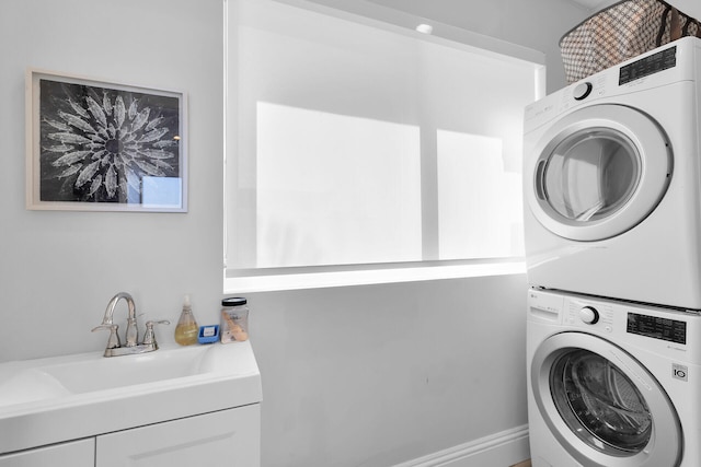 laundry area featuring sink and stacked washer and clothes dryer