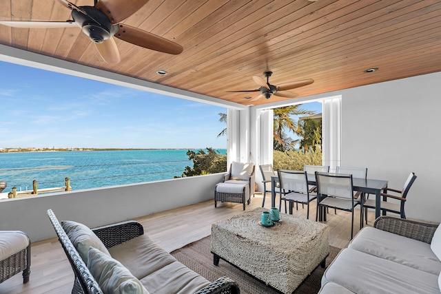 view of patio with a water view, ceiling fan, outdoor lounge area, and a balcony