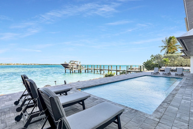 view of swimming pool with a water view, a dock, and a patio