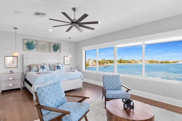 bedroom featuring a water view, ceiling fan, and dark hardwood / wood-style floors