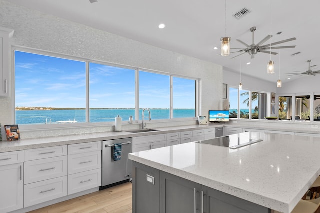 kitchen featuring sink, a center island, a water view, white cabinets, and stainless steel dishwasher