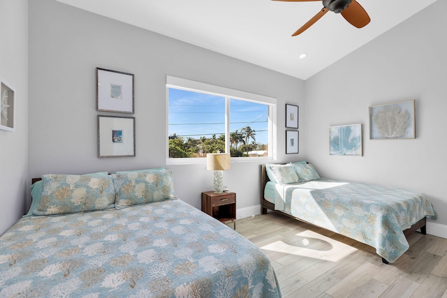 bedroom with ceiling fan, lofted ceiling, and light hardwood / wood-style floors