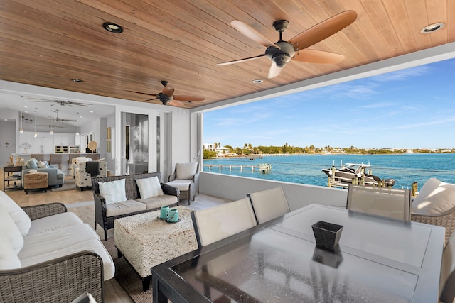 view of patio / terrace featuring an outdoor living space, ceiling fan, and a water view