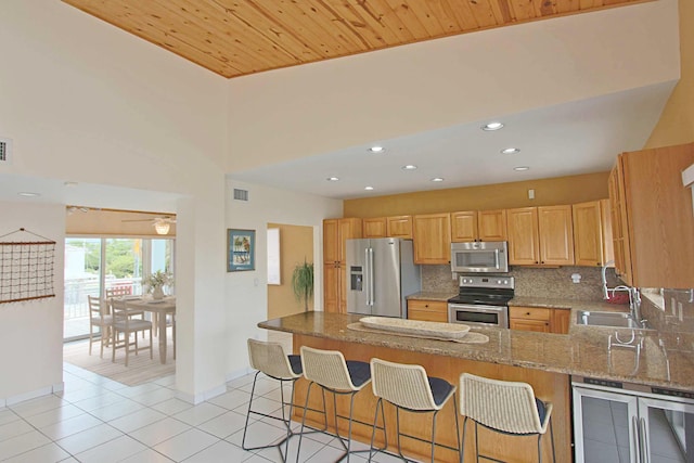 kitchen with sink, appliances with stainless steel finishes, wine cooler, decorative backsplash, and kitchen peninsula