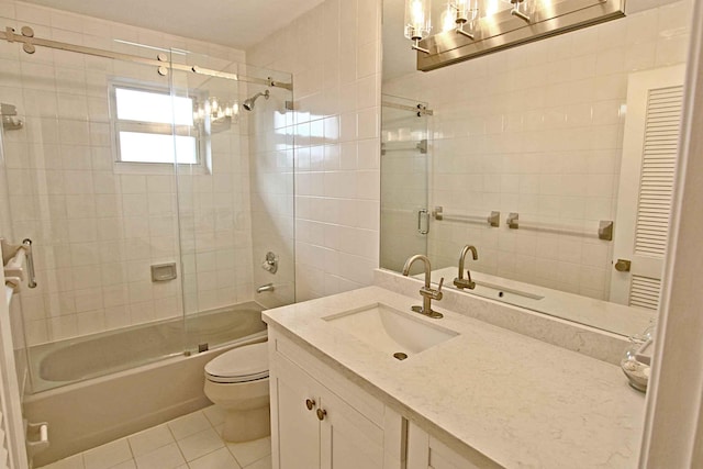 full bathroom with tile patterned flooring, bath / shower combo with glass door, vanity, and toilet