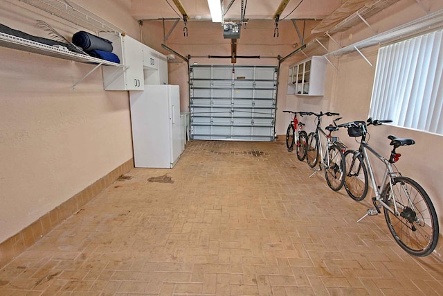 garage featuring a garage door opener and white fridge