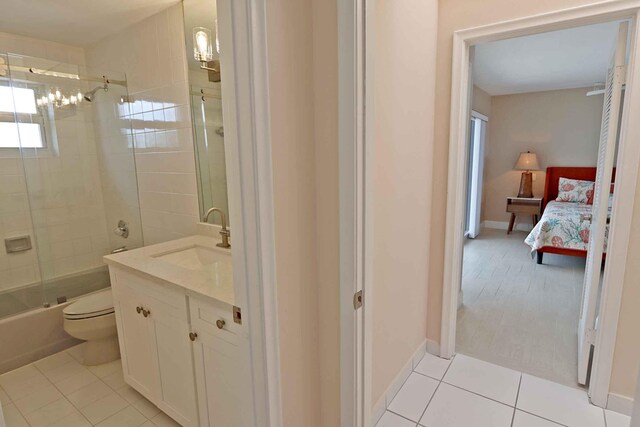 full bathroom with tile patterned flooring, vanity, shower / bath combination with glass door, and toilet