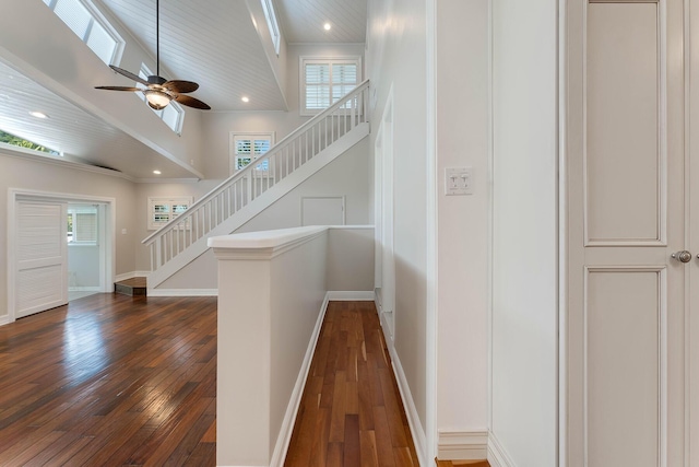 stairway featuring hardwood / wood-style flooring, a towering ceiling, and ceiling fan