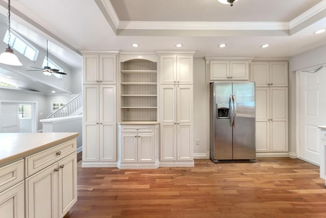 kitchen with light hardwood / wood-style flooring, a skylight, a tray ceiling, and stainless steel fridge