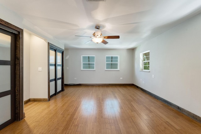 spare room with ceiling fan and light wood-type flooring