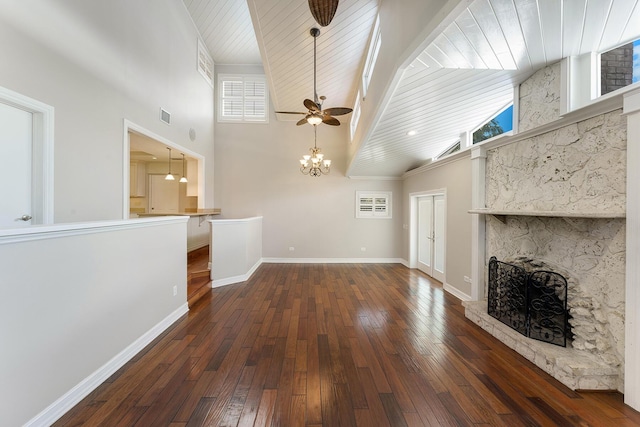 unfurnished living room with a stone fireplace, ceiling fan with notable chandelier, high vaulted ceiling, wood ceiling, and dark wood-type flooring