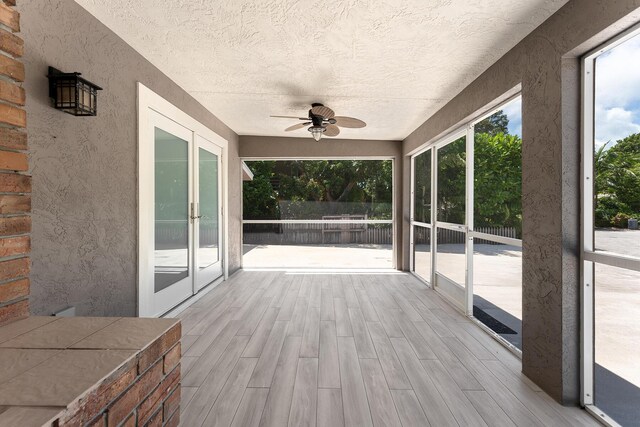 unfurnished sunroom featuring plenty of natural light and ceiling fan