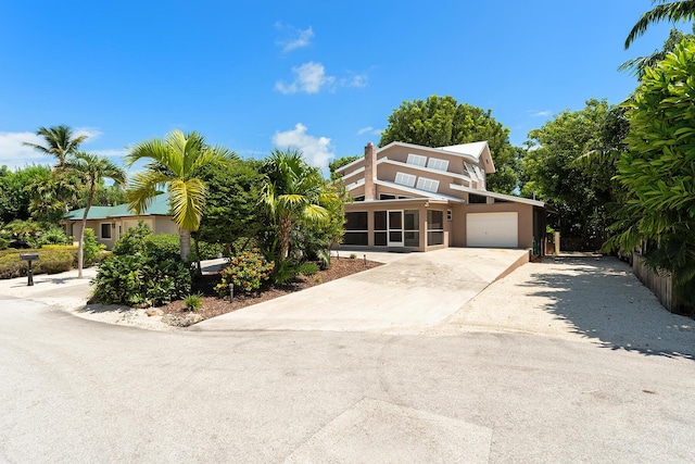 view of front of home featuring a garage and a sunroom