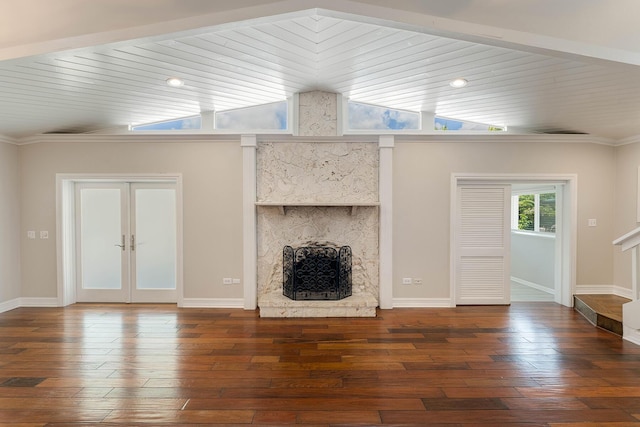 unfurnished living room with dark wood-type flooring, french doors, wood ceiling, vaulted ceiling, and a large fireplace