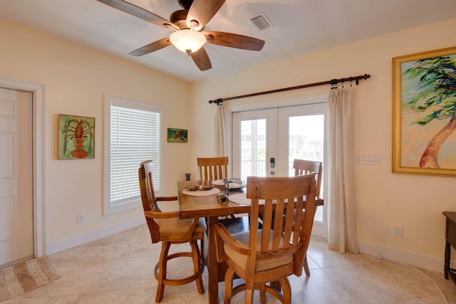 tiled dining area with ceiling fan and french doors