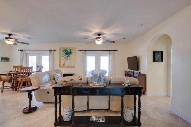 living room with a wealth of natural light, ceiling fan, and french doors