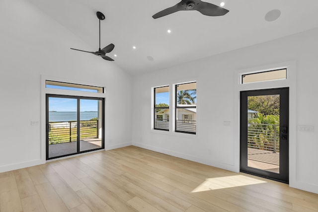 spare room featuring a ceiling fan, plenty of natural light, high vaulted ceiling, and light wood finished floors