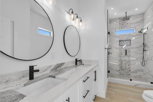 full bathroom with a wealth of natural light, a sink, and a marble finish shower