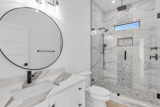 bathroom featuring toilet, a marble finish shower, and vanity