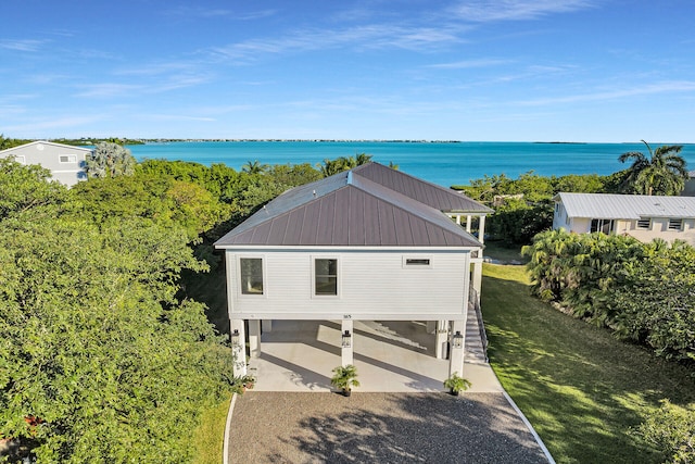 view of front of house with metal roof, a water view, and a front yard