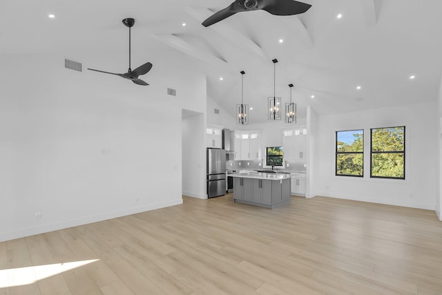 kitchen with visible vents, ceiling fan, open floor plan, a center island, and freestanding refrigerator