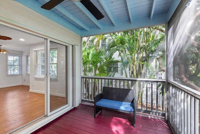 sunroom / solarium featuring beamed ceiling and ceiling fan