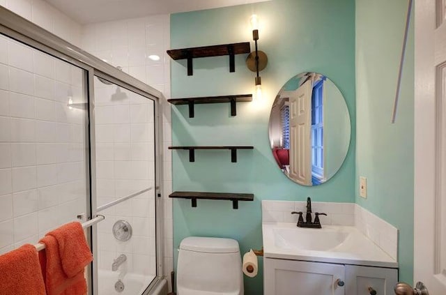 full bathroom featuring enclosed tub / shower combo, vanity, and toilet