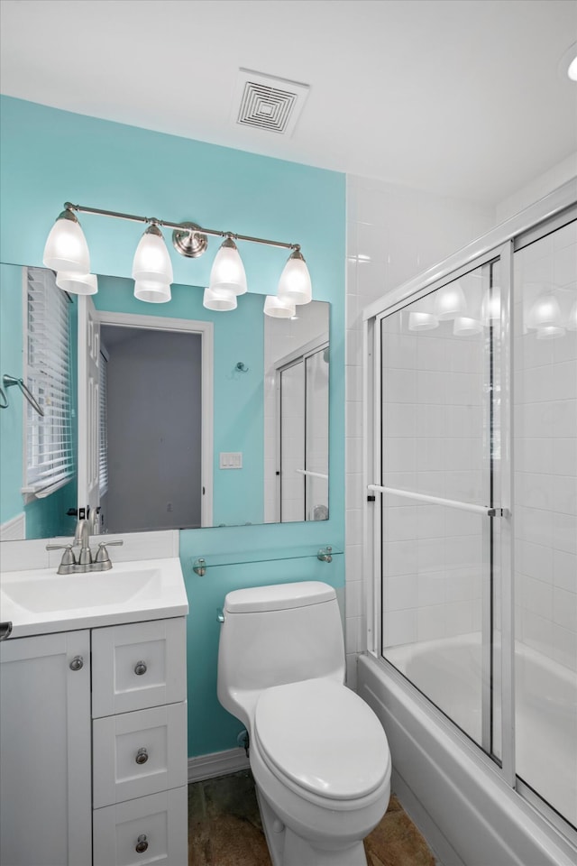 full bathroom with vanity, shower / bath combination with glass door, and toilet