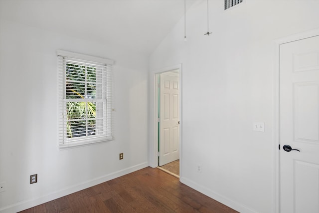 empty room featuring dark hardwood / wood-style flooring and vaulted ceiling