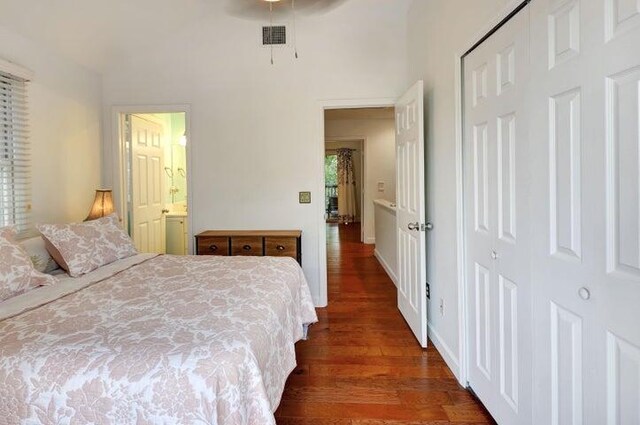 bedroom with ceiling fan, ensuite bathroom, dark hardwood / wood-style floors, and a closet