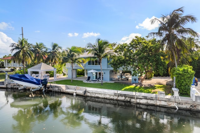 view of dock with a gazebo, a patio, and a water view