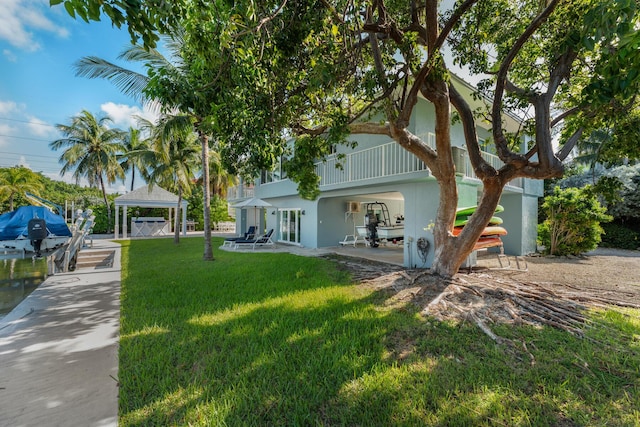 back of property featuring a gazebo and a lawn