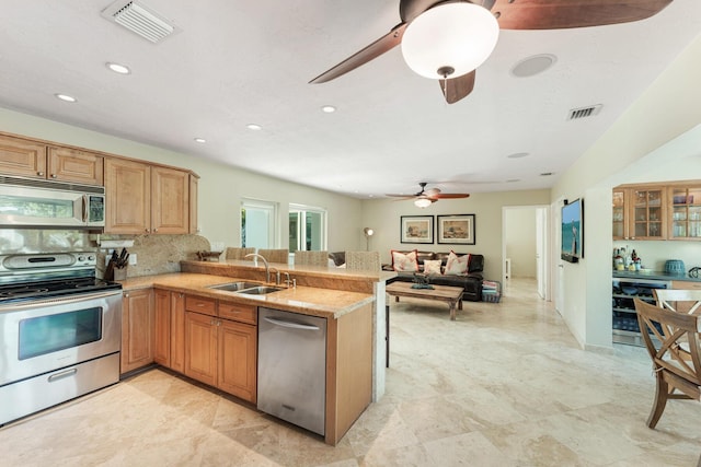 kitchen with stainless steel appliances, sink, wine cooler, and kitchen peninsula