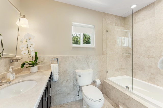 full bathroom featuring toilet, vanity, bath / shower combo with glass door, and tile walls