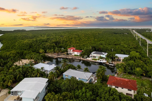 aerial view at dusk featuring a water view