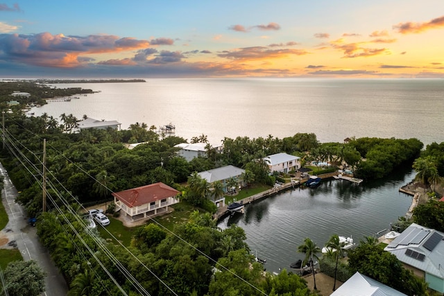 aerial view at dusk featuring a water view