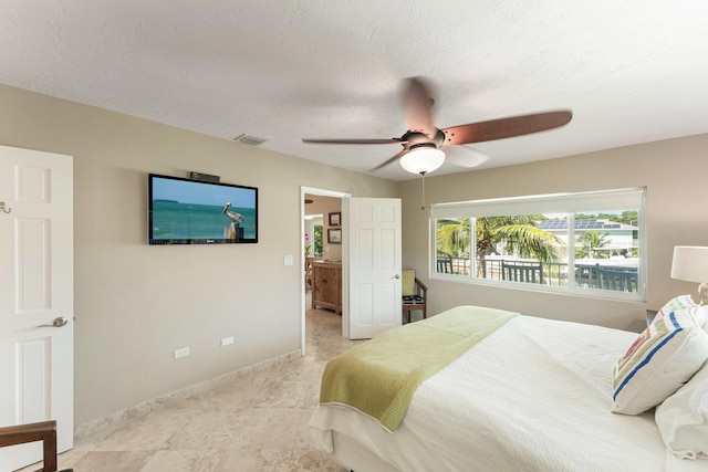 bedroom featuring ceiling fan and a textured ceiling