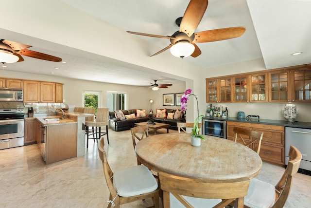 dining area with wine cooler, ceiling fan, and indoor wet bar