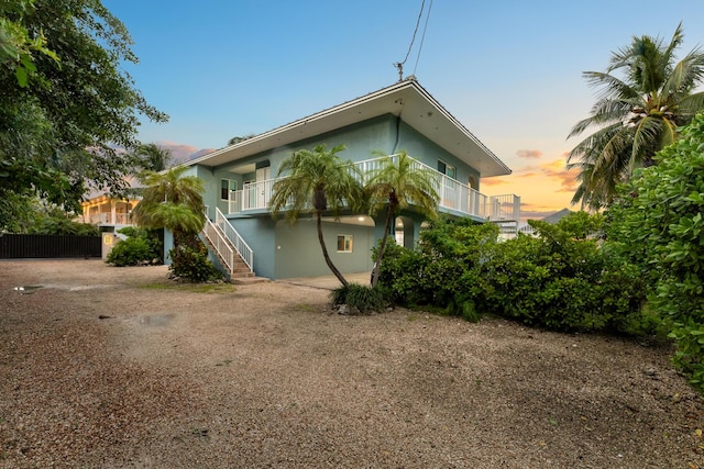 back house at dusk featuring a balcony